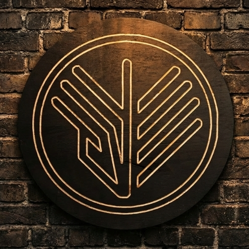 Circular engraved wooden logo sign mounted on brick wall